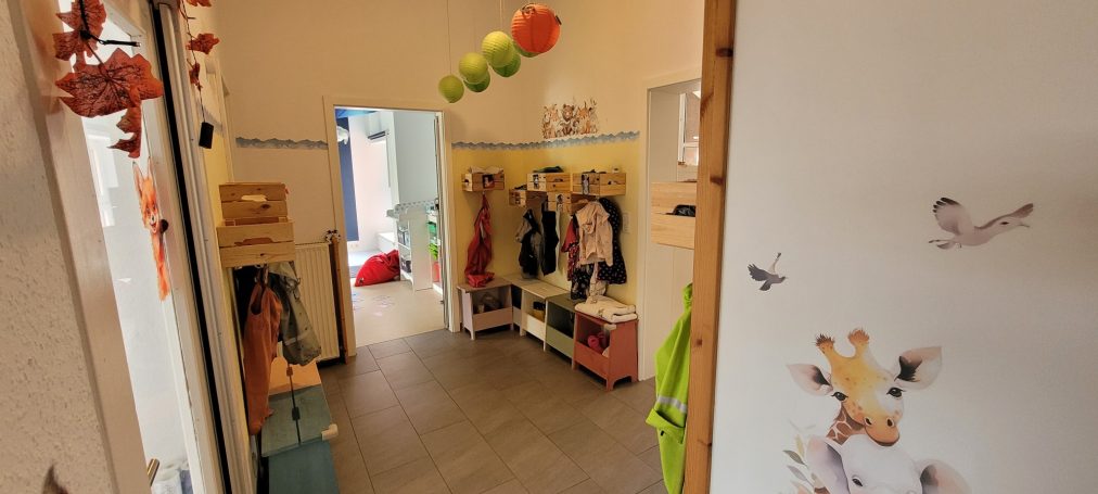 Blick in einen bunten Raum mit Kindermode und Spielzeug, fröhliche Dekoration.